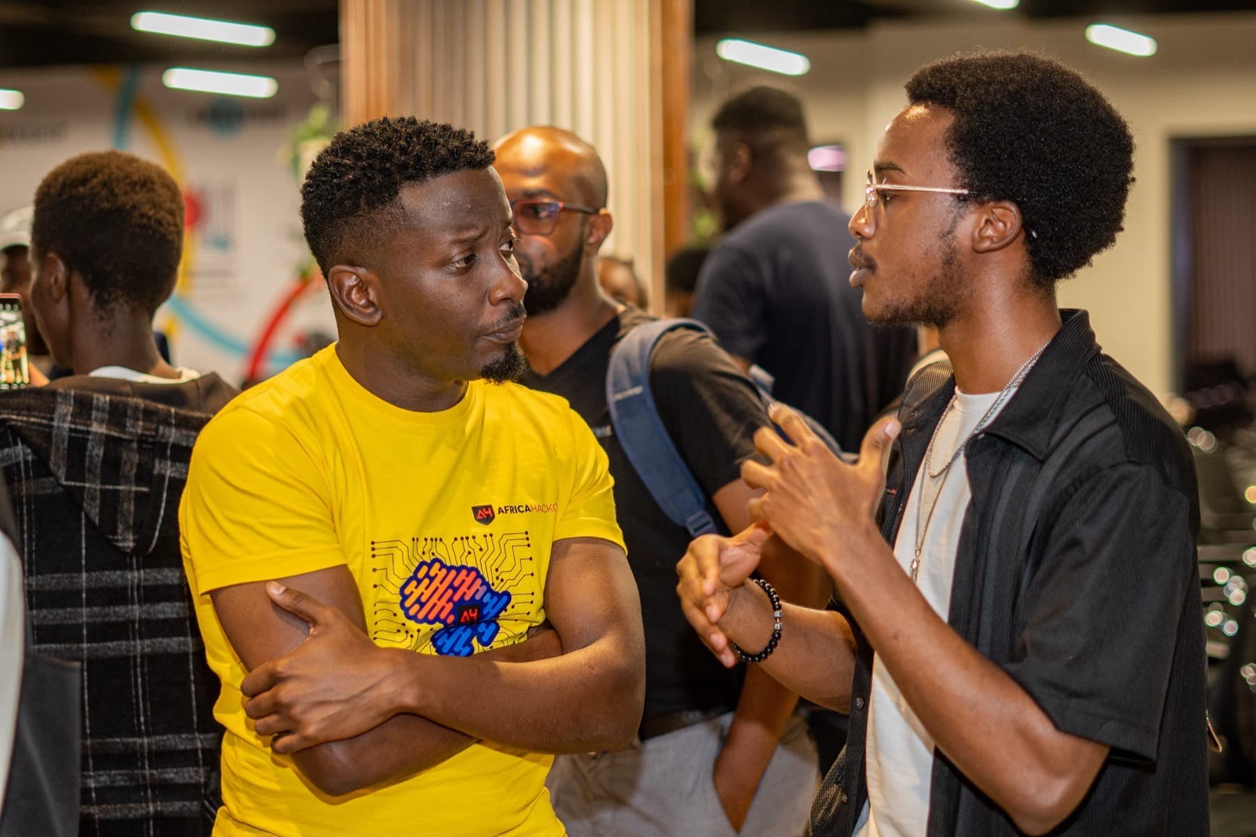 Two members of the AfricaHackon community in conversation at a meetup